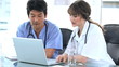 Serious practitioners talking together in front of a laptop