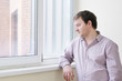 Courageous middle age man looking at snow into the window