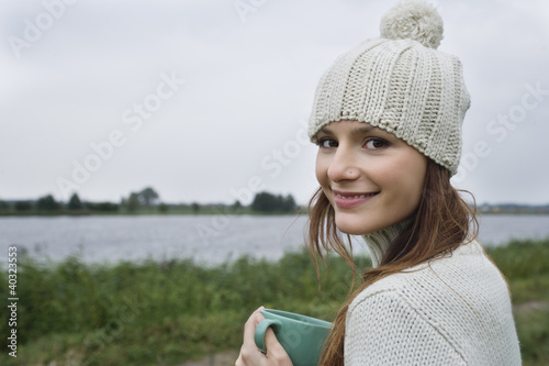 Photo: Young woman holding mug, close-up, portrait Young woman holding mug, close-up, portrait