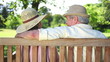 Mature couple wearing hats kissing on a bench