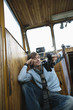 Young man holding binoculars, smiling