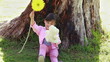 Smiling girl holding a flower and a teddy bear