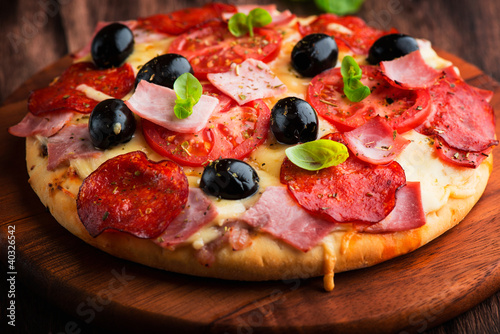 Photo: Pizza with salami, ham and tomatoes Pizza with salami, ham and tomatoes