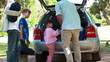 Rear view of a man placing his cooler in his car