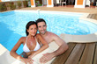 Young smiling couple bathing in private pool