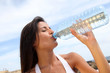 Portrait of attractive woman holding bottle of water outside