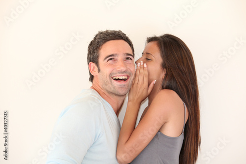 Photo: Beautiful woman whispering to boyfriend's ear Beautiful woman whispering to boyfriend's ear