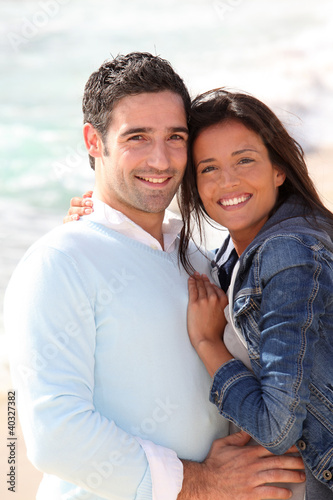 Photo: Romantic couple walking by the beach Romantic couple walking by the beach