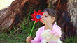 Smiling girl holding a red pinwheel