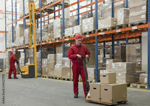 Photo: workers in uniforms and safety helmets working in storehouse workers in uniforms and safety helmets working in storehouse