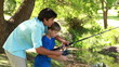 Happy father and son using a fishing rod