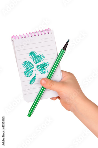 Photo: children's hands hold notebook with a painted clover children's hands hold notebook with a painted clover