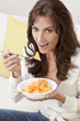 Photo: Brunette Woman Eating Melon At Home on Sofa Brunette Woman Eating Melon At Home on Sofa