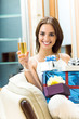 Woman with champagne and gifts at home