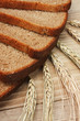 slices of rye bread and ears of corn on a wooden table