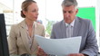Two colleagues talking while reading a document