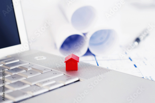 Photo: Red model house and laptop Red model house and laptop