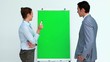 Two business people talking in front of a board