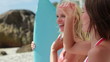 Video: Women standing by the surfboard pointing outwards Women standing by the surfboard pointing outwards