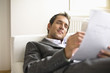 Businessman lying on sofa, reading document
