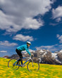 Spring bike riding - woman downhill on bike in dandelion