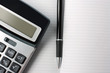 calculator, pen and open diary