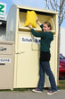 Frau am Altkleidercontainer