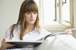 Young woman reading magazine