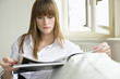Young woman reading magazine