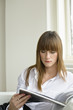 Young woman reading magazine
