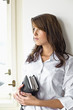 Young woman holding diary, looking away