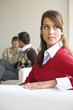 Young woman sitting on sofa with mid adult couple