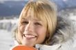 Young woman holding snowboard, smiling, portrait