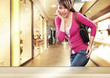Photo: Cute lady looking at a shop window in shopping center Cute lady looking at a shop window in shopping center
