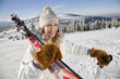 Young woman holding ski and pole