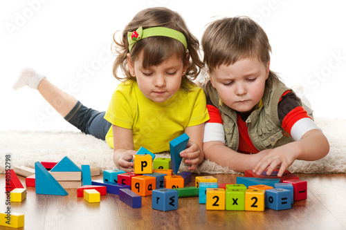 Photo: Two children are playing on the floor Two children are playing on the floor