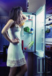 Woman wearing pajamas looking at fridge