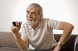 Senior man holding smoke pipe, smiling