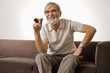 Senior man holding smoke pipe, smiling