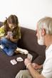Girl playing cards with grandfather
