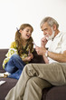 Senior man looking at cards while girl smiling