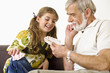Senior man and girl looking at playing cards