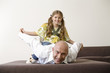 Girl sitting on man's back, holding hands, smiling, portrait