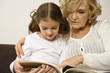Senior woman with granddaughter looking at photograph album