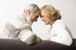 Foto: Senior couple sitting head to head, side view Senior couple sitting head to head, side view