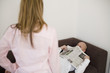 Woman standing while man lying with newspaper on face
