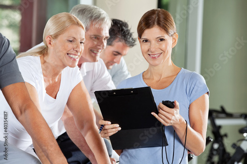 Photo: Fitnesstrainierin mit Klemmbrett und Stoppuhr Fitnesstrainierin mit Klemmbrett und Stoppuhr