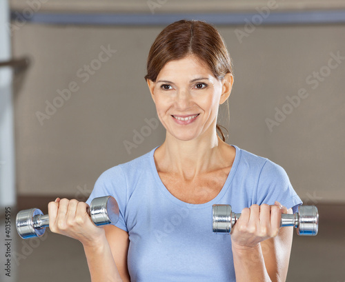Photo: Frau beim Hanteltraining im Fitnesscenter Frau beim Hanteltraining im Fitnesscenter