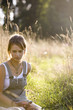Photo: Mid adult woman sitting in field Mid adult woman sitting in field