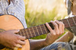 Mid adult man playing guitar, close-up